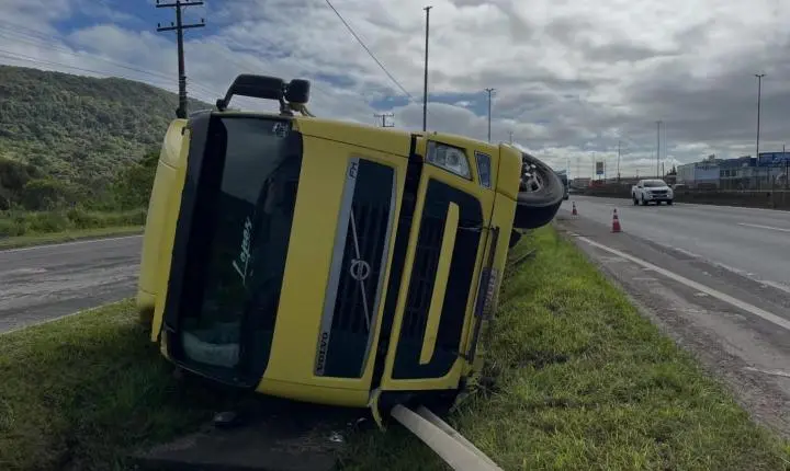 Caminhão carregado de cascalho tomba na BR-101, em Osório