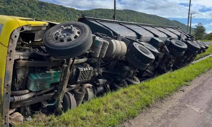 Caminhão carregado de cascalho tomba na BR-101, em Osório